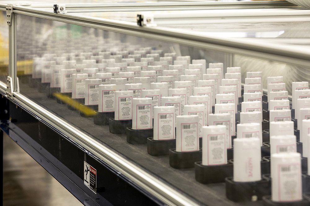 Deodorant containers moving through the packing process