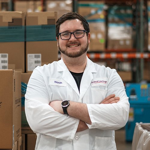 Portrait of a smiling man with his arms crossed wearing a lab coat.