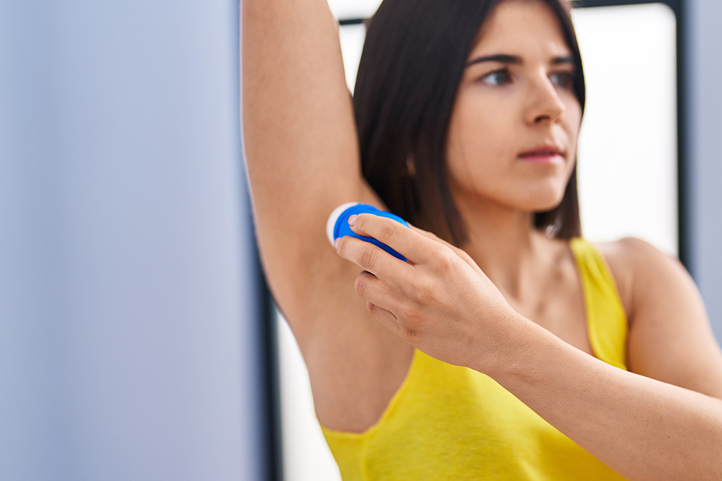 Woman applying deodorant